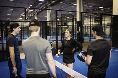 Group of friends talking at indoor padel court