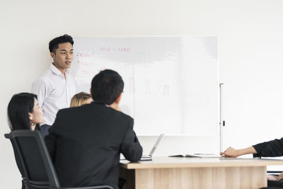 Rear view of people sitting in front of office
