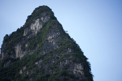 Low angle view of rock formation against clear blue sky