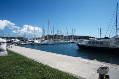 Sailboats moored at harbor