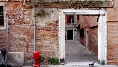 Alley with ancient brick wall building in venice, italy