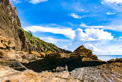 Rock formations in sea against sky