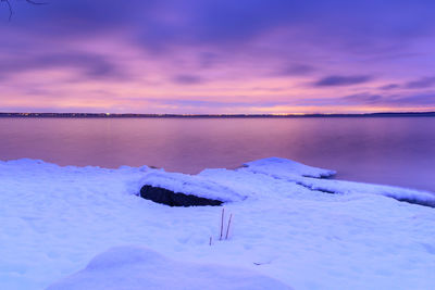 Scenic view of frozen lake against sky during sunset