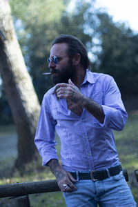 Side view of young man looking away while standing outdoors