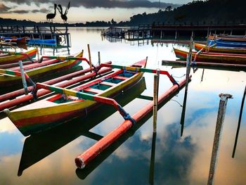 Boats moored in lake against sky