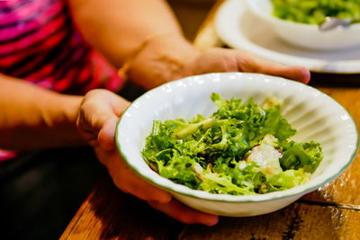 Midsection of person holding food at table