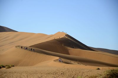 Scenic view of desert against clear blue sky