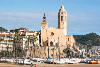 Sailboats in city against buildings