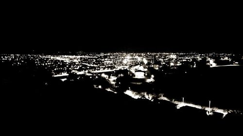 High angle view of illuminated cityscape against sky at night