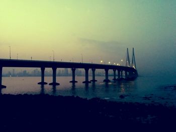 Bridge over river at sunset