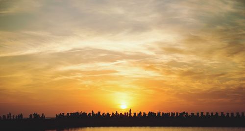 Silhouette people against sky during sunset