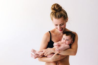 Woman holding baby against white background