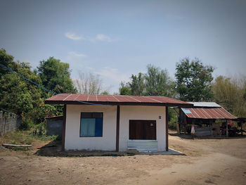 House amidst trees and buildings against sky