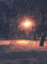 Snow covered landscape against sky during sunset