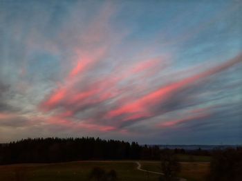 Scenic view of field against sky at sunset