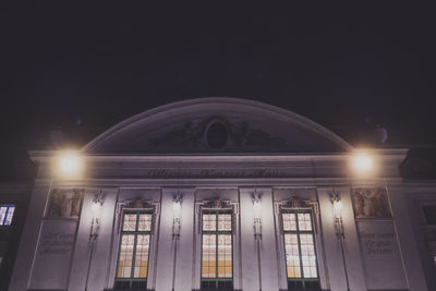 Low angle view of illuminated building against sky at night