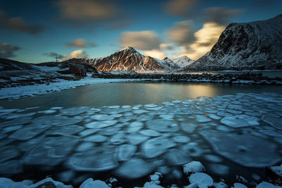 View of lake against mountain range during winter