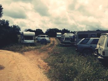 Cars on road amidst field against sky