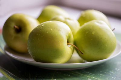 High angle view of granny smith apples in plate on table