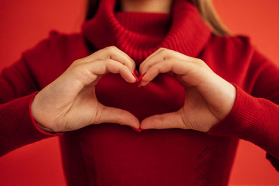 Midsection of woman holding heart shape