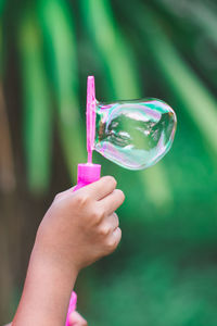 Close-up of hand making bubbles with wand