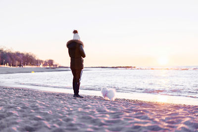 Full length of man on beach against sky during sunset