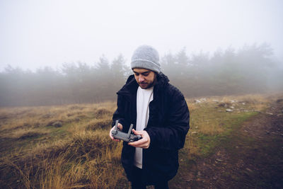 Full length of young man photographing while standing on land