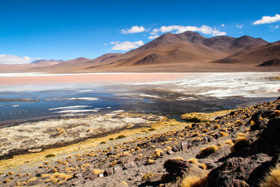 Scenic view of landscape and mountains against blue sky