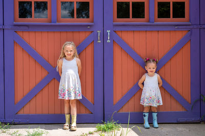 Portrait of smiling girl standing against door