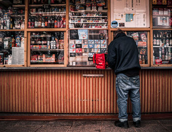 Rear view of man standing in front of store