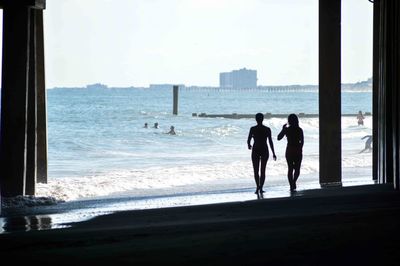 People at beach against sky