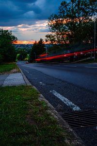 Trees by railroad tracks against sky