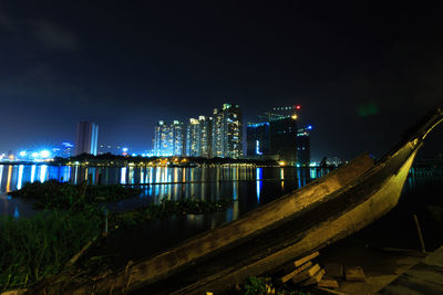 Old boat moored on river at night