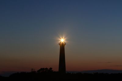 Low angle view of illuminated sun against sky during sunset