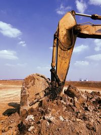 Metallic structure by rocks on field against sky