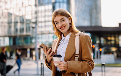 Young woman using mobile phone in city