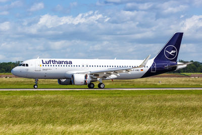 Side view of airplane on airport runway against sky