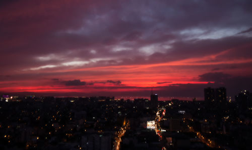 Aerial view of illuminated city against sky at sunset