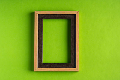 Close-up of empty chair against green background