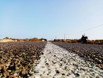 Surface level of road on field against clear sky