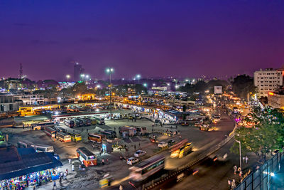 Aerial view of illuminated street amidst buildings in city at night