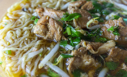 Close up egg noodle soup with pork and vegetable.