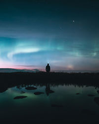 Man with flashlight standing under sky at night