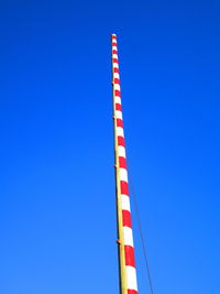 Low angle view of crane against clear blue sky