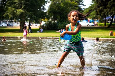 Full length of happy girl playing in water