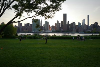 People in park by city against sky
