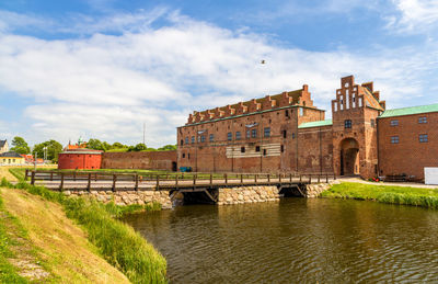 Arch bridge over river against buildings