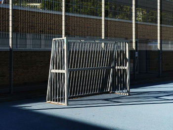 Empty road by fence in city