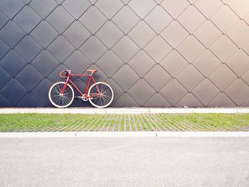 Bicycle parked against patterned wall