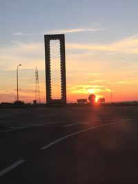 Silhouette road against sky during sunset